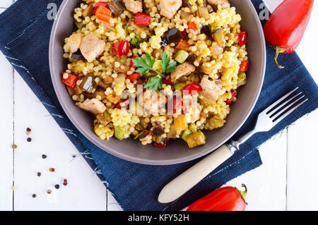 Un régime alimentaire léger avec salade, couscous de légumes (courgettes, aubergines, carottes, poivrons, oignons), les morceaux de poulet sur un bois blanc backgroun Banque D'Images