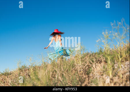 Belle femme en robe bleue danser et profiter de la nature à l'Antelope Valley California Poppy réserver à Lancaster, CA. Banque D'Images