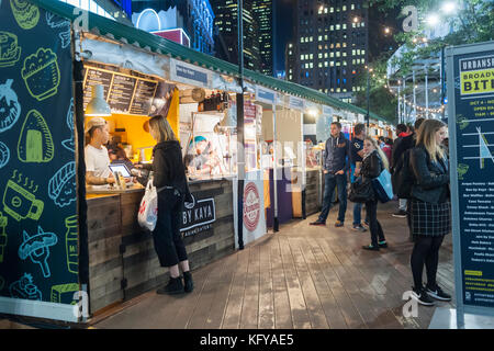 Profitez des gourmets les offrandes à Broadway de urbanspace bites marché plein air dans la région de Greeley Square à New York le mercredi, Octobre 25, 2017. le populaire salon de l'alimentation temporaire, de l'Herald square/ Greeley Square Shopping District, apporte toute une gamme de restaurants offrant un coin repas extérieur attire l'expérience des employés de bureau de la faim dans la région, les consommateurs et les touristes. (© richard b. levine) Banque D'Images