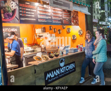 Profitez des gourmets les offrandes à Broadway de urbanspace bites marché plein air dans la région de Greeley Square à New York le mercredi, Octobre 25, 2017. le populaire salon de l'alimentation temporaire, de l'Herald square/ Greeley Square Shopping District, apporte toute une gamme de restaurants offrant un coin repas extérieur attire l'expérience des employés de bureau de la faim dans la région, les consommateurs et les touristes. (© richard b. levine) Banque D'Images