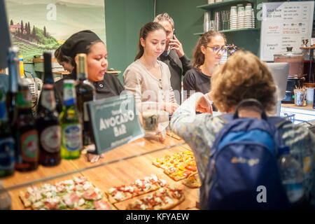 Profitez de l'offre des gourmets cafe toscano à Broadway de urbanspace bites marché plein air dans la région de Greeley Square à New York le mercredi, Octobre 25, 2017. le populaire salon de l'alimentation temporaire, de l'Herald square/ Greeley Square Shopping District, apporte toute une gamme de restaurants offrant un coin repas extérieur attire l'expérience des employés de bureau de la faim dans la région, les consommateurs et les touristes. (© richard b. levine) Banque D'Images