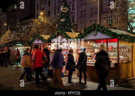 Prague, République tchèque - Le 10 décembre 2016 : les gens qui passent par des kiosques lumineux avec des souvenirs et des décorations au cours de marché de noel. Banque D'Images