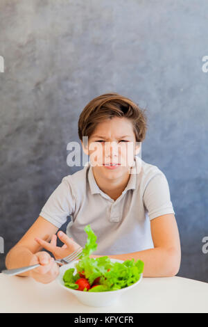 Cute teen boy n'aimez eating salad Banque D'Images