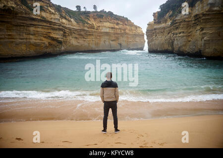 Baie abritée dans l'Australie et l'homme se tient avec les mains dans ses poches à la plage Banque D'Images