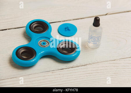 Fidget bleu spinner le jouet sur fond de bois blanc Banque D'Images