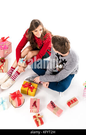 Couple assis parmi les cadeaux de Noël Banque D'Images