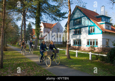 Balade à vélo dans le Touquet (nord de la France). Deux couples riding bikes sur une voie cyclable et passant par les maisons typiques de Le Touquet Banque D'Images