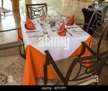 Table avec des assiettes et des verres prêts pour servir la nourriture Banque D'Images