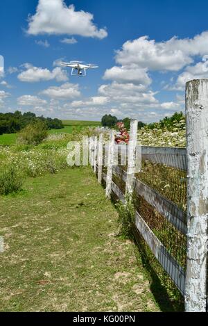 Teen boy flying dji phantom 4 pro + drone pour vérifier l'escrime sur rural farm in USA. Banque D'Images