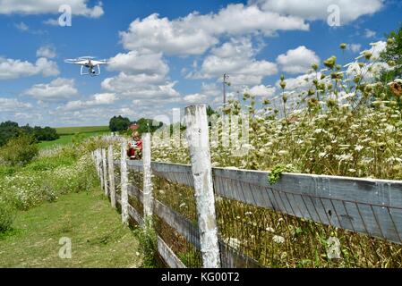 Teen boy flying dji phantom 4 pro + drone pour vérifier l'escrime sur rural farm in USA. Banque D'Images