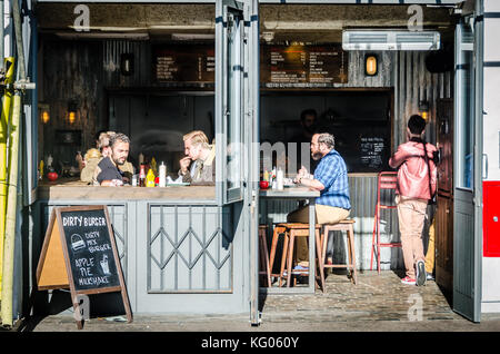 Les gens de manger des hamburgers dans un bar Banque D'Images