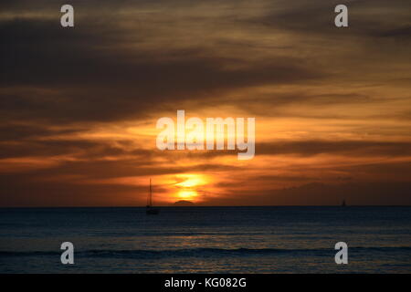 Voiliers à l'horizon au coucher du soleil sur la plage de Waikiki à Hawaï. Banque D'Images