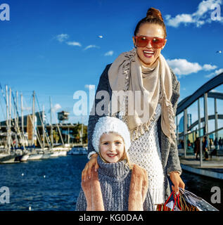 À Barcelone pour un parfait présent. portrait of smiling trendy la mère et l'enfant avec les sacs sur le quai à Barcelone, Espagne Banque D'Images