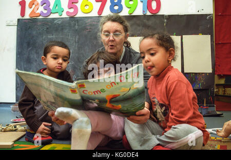 La lecture de l'enseignant à un groupe d'enfants à l'école maternelle Banque D'Images