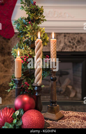 Salle de séjour décorée pour Noël avec des chandeliers, et un bas accrochés à la cheminée Banque D'Images