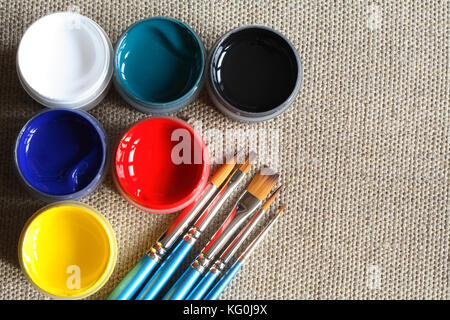 Ensemble de pinceaux et peinture de couleur sur fond de toile Banque D'Images