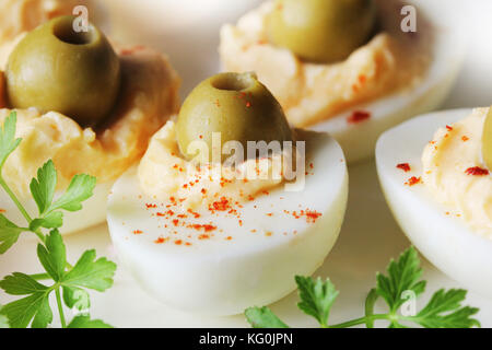 Oeufs farcis épicés garni d'olives vertes . Banque D'Images