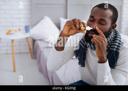 Jeune homme malade au cours de sa procédure ordinaire à la maison Banque D'Images