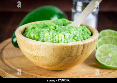 Avocado guacamole mexicain sur molcajete procédure traditionnelle. Banque D'Images