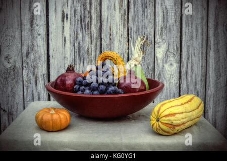 Gros plan sur les fruits et légumes récoltés dans la fin de l'été, dans le panier rouge, sur tan, nappe décorée de indian corn- fall still life concept Banque D'Images