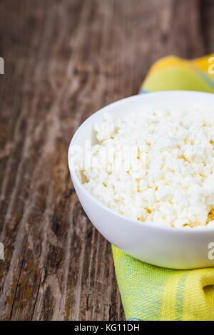 Le fromage blanc dans un bol blanc sur la table. des aliments sains pour le petit déjeuner. Banque D'Images