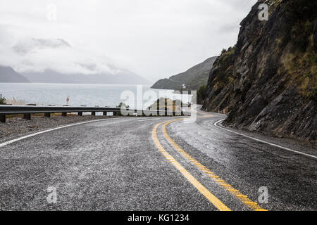 Route sinueuse le long du lac Wakatipu menant à Queenstown en Nouvelle-Zélande île du Sud un jour de pluie Banque D'Images