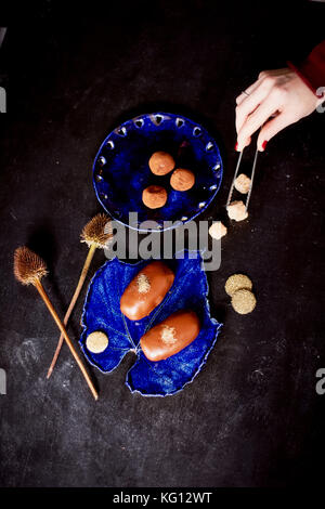 Gâteau de pommes de terre au chocolat avec de la poudre d'or sur le bleu profond de la plaque. Une œuvre d'art culinaire Banque D'Images