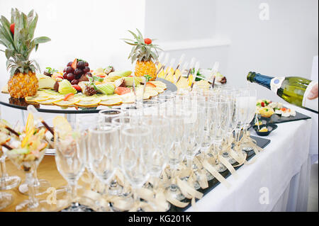 Un beau fruit bar servant une table de fête. le serveur verse du Champagne dans des verres à vin. Banque D'Images