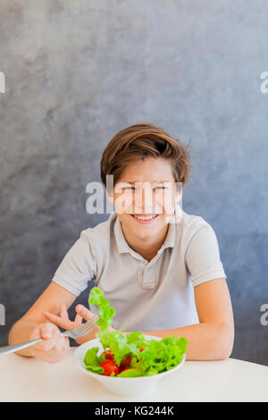 Cute teen boy n'aimez eating salad Banque D'Images