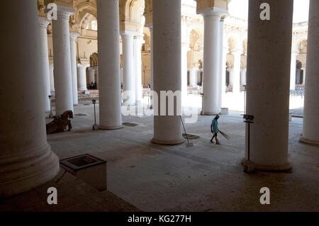 Nettoyeur avec pinceau de palme balayant mille piliers Hall à l'intérieur du 17ème siècle Thirumalai Nayakkar Mahal, Madurai, Tamil Nadu, Inde, Asie Banque D'Images