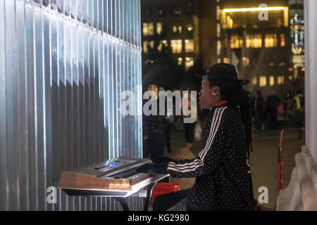 New York, NY 27 octobre 2017 - un artiste de rue coincé entre une jambe de Washington square arch et ai weiwei's sculpture, 'Les bonnes clôtures font les bons voisins" joue sur un automne chaud nuit Greenwich village. © stacy walsh rosenstock Banque D'Images