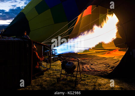 Le gonflage de l'équipage d'accueil hot air balloon avec flamme, Albuquerque International Balloon Fiesta, Albuquerque, Nouveau Mexique USA Banque D'Images