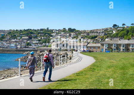 Couple walking la côte sud-ouest chemin dans Penzance, Cornwall, England, UK. Banque D'Images