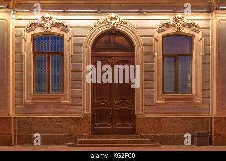 Deux fenêtres et porte dans une rangée sur la façade illuminée de nuit de l'immeuble Vue avant, st. Petersburg, Russie Banque D'Images