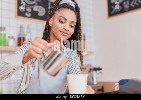 Verser le lait dans le café barista Banque D'Images