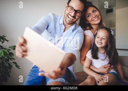 Famille heureuse de prendre dans leur maison selfies Banque D'Images