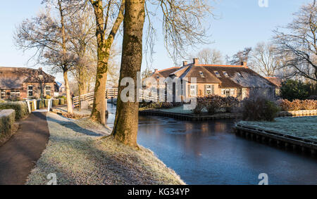 L'hiver à giethoorn dans l'Overijssel avec herbe gelée et les canaux, les maisons d'adobe monumental vieux et faible du soleil, aux Pays-Bas. Banque D'Images
