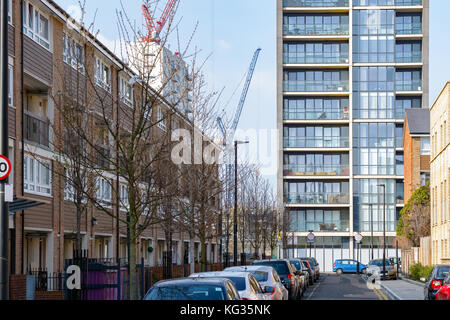 English maisons mitoyennes en contraste avec le luxe moderne des appartements et des grues dans l'arrière-plan Banque D'Images