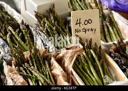 Ferme d'asperges fraîches sur l'affichage par 'aucun' signe de pulvérisation à Ann Arbor dans le marché des producteurs du marché historique de Kerrytown District de Ann Arbor, Michigan, USA. Banque D'Images