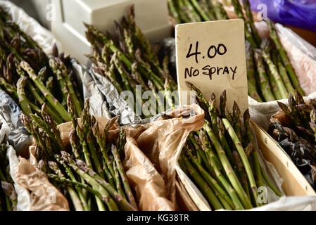 Ferme d'asperges fraîches sur l'affichage par 'aucun' signe de pulvérisation à Ann Arbor dans le marché des producteurs du marché historique de Kerrytown District de Ann Arbor, Michigan, USA. Banque D'Images