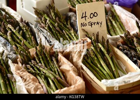 Ferme d'asperges fraîches sur l'affichage par 'aucun' signe de pulvérisation à Ann Arbor dans le marché des producteurs du marché historique de Kerrytown District de Ann Arbor, Michigan, USA. Banque D'Images