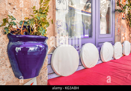 Retro vue de charmantes rues alacati.table en bois et pots de pourpre sur le mur. Banque D'Images