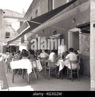 Années 1950, historiques, des familles appréciant le déjeuner à l'extérieur d'un restaurant italien, Naples, Italie. Banque D'Images