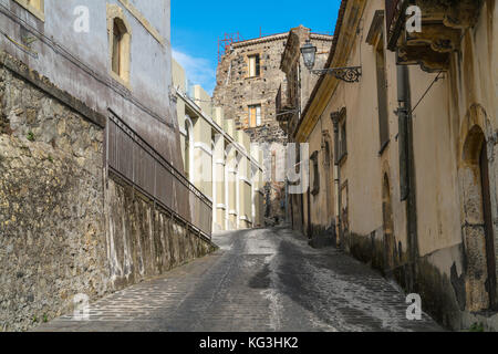 Rue en pente à Castiglione di Sicilia, Italie Sicile, avec galets de basalte et de pittoresques bâtiments anciens sur une journée ensoleillée Banque D'Images