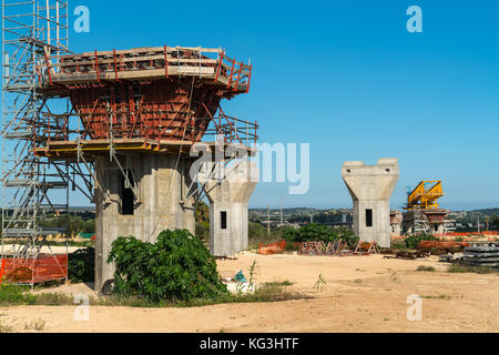 La construction d'un pont ou d'autoroute Autostrada avec grande grue à portique levage en sections de route entre piliers. la Sicile, Italie Banque D'Images