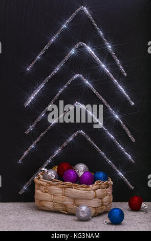 Boîte avec des décorations de Noël et de l'abrégé de sapin de Noël. un fond noir sur lequel les contours de branches de sapins d'mishuryryady sont fixe Banque D'Images