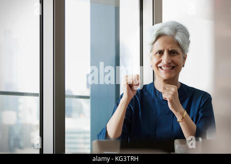 Smiling woman cheering with hand fists