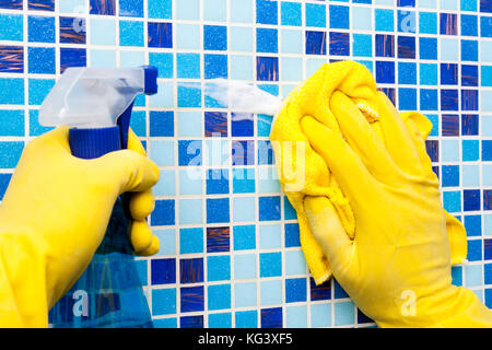 Personne les petits travaux dans la maison de nettoyage salle de bains au mur carrelé avec pulvérisateur et serviette en microfibre Banque D'Images