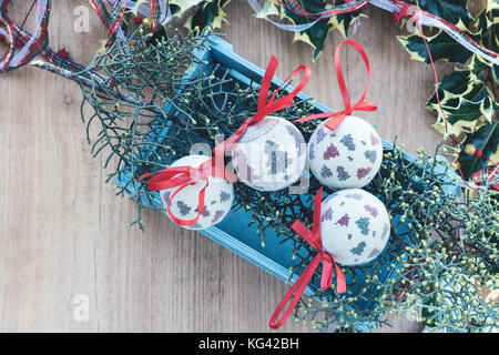 Vue de dessus des boules de noël. photo encadrée de feuilles de gui sur fond de bois. Banque D'Images