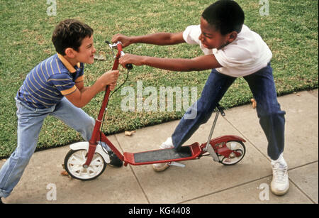 La lutte contre les enfants Enfant prenant un autre garçon jouet des deux garçons qui luttent pour la possession de M. scooter © Myrleen Pearson Banque D'Images